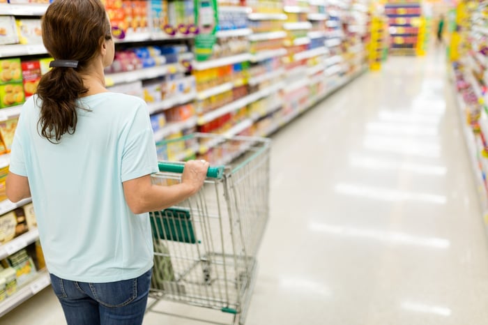 A person pushing a shopping cart in a store.