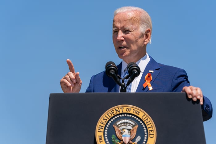 Joe Biden delivering remarks to an outdoor crowd from behind the presidential podium.