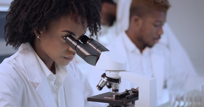 Scientist looking into a microscope.