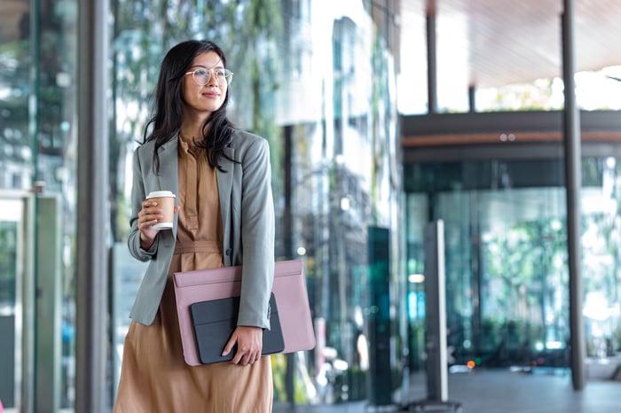 Young business professional with coffee and business case.