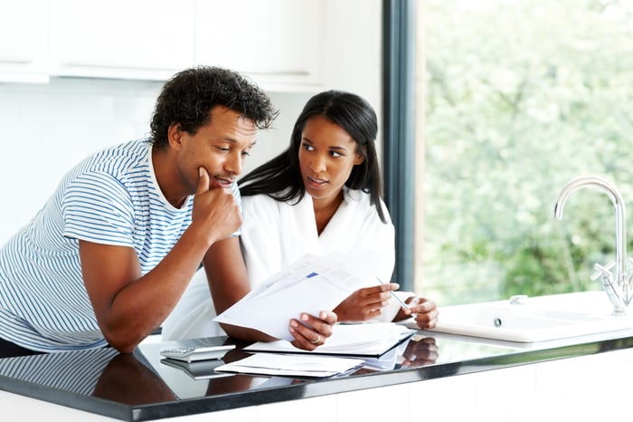 Two people look through paperwork.
