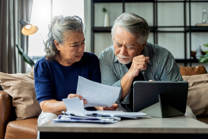 Two people with concerned expressions looking at a document.