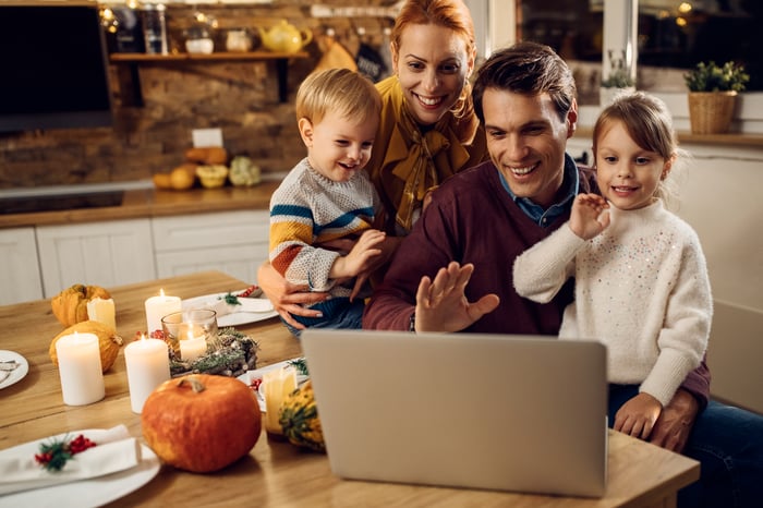 Family gathered around a laptop during the fall holidays.