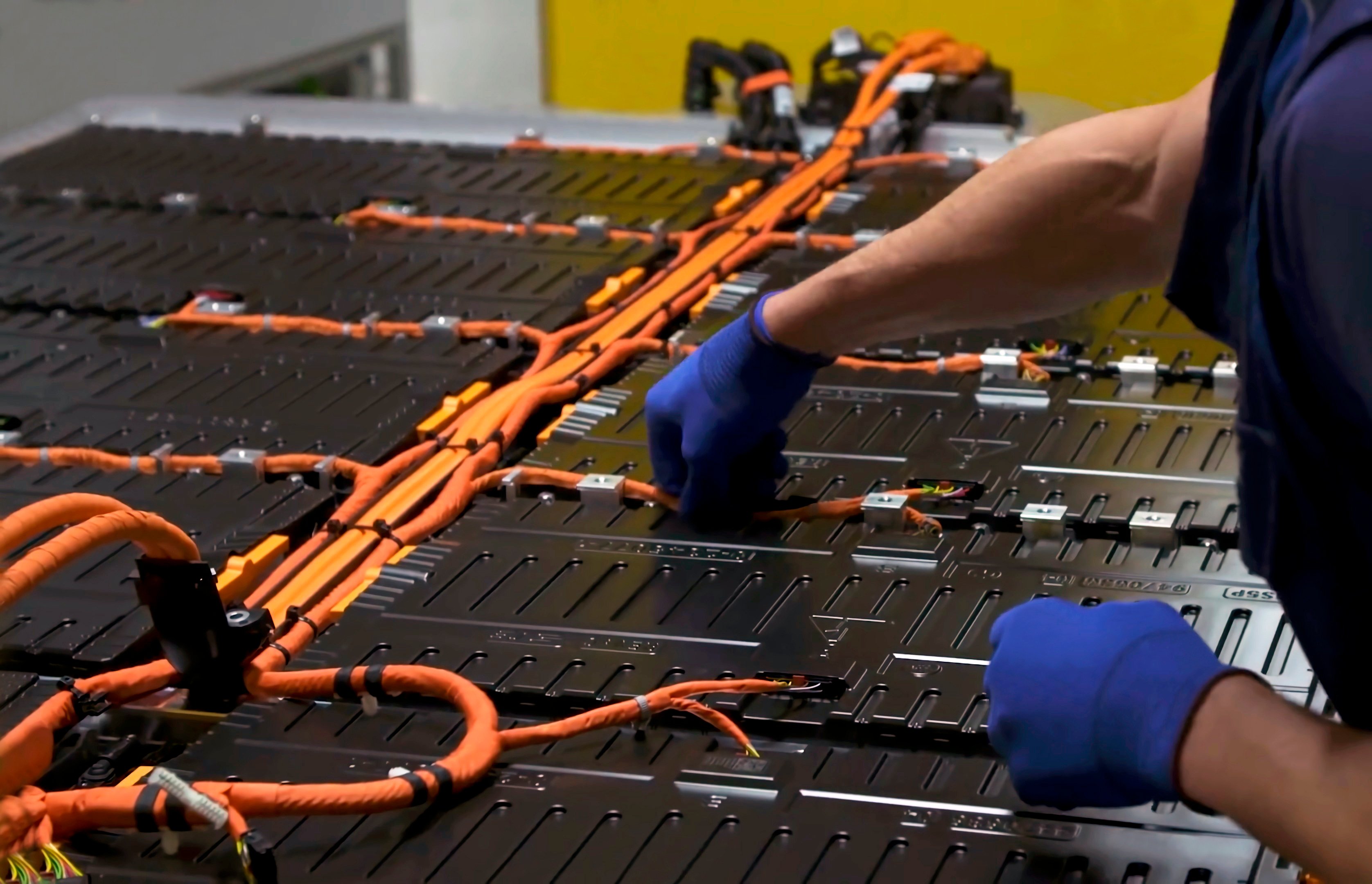 Person assembling a lithium battery for an electric vehicle.