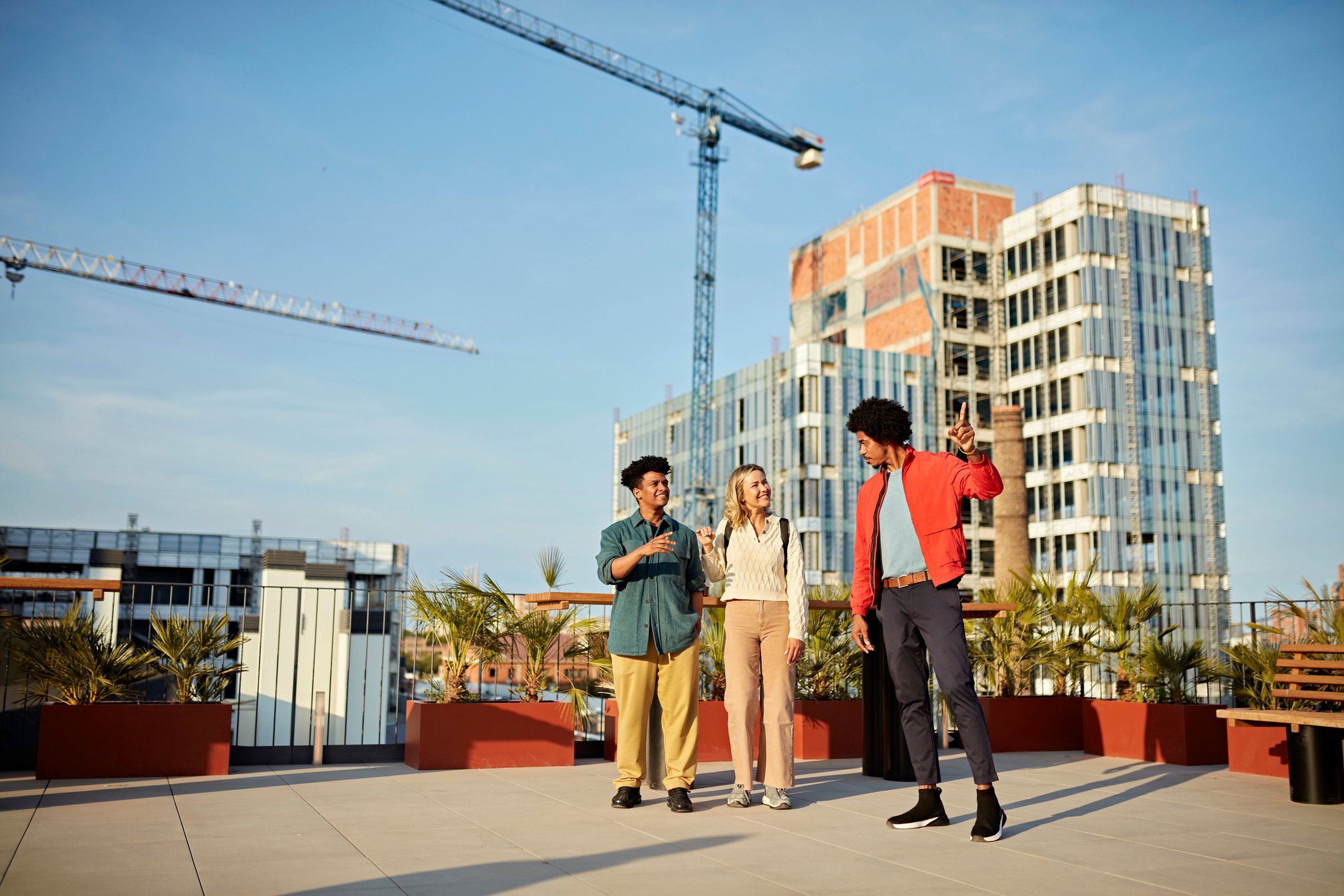 three people on roof talking commercial real estate