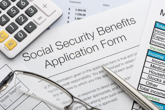 A calculator sits atop a Social Security benefits application.