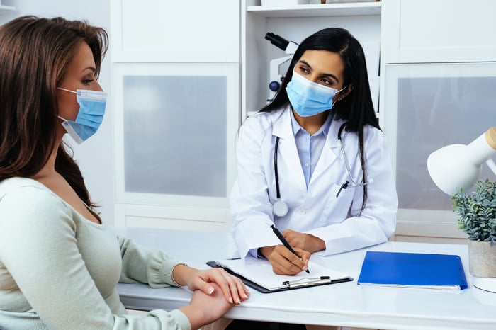 A patient and doctor speak to each other during an appointment.