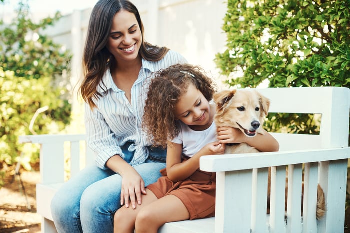 Mother and child play with family pet.