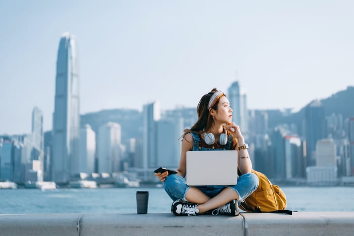 A person works on a laptop at Victoria Harbor in Hong Kong.