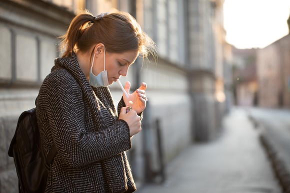 A person smokes a cigarette during the COVID-19 pandemic.