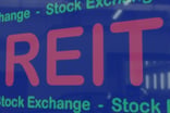 A computer screen with the acronym REIT in large letters on it.