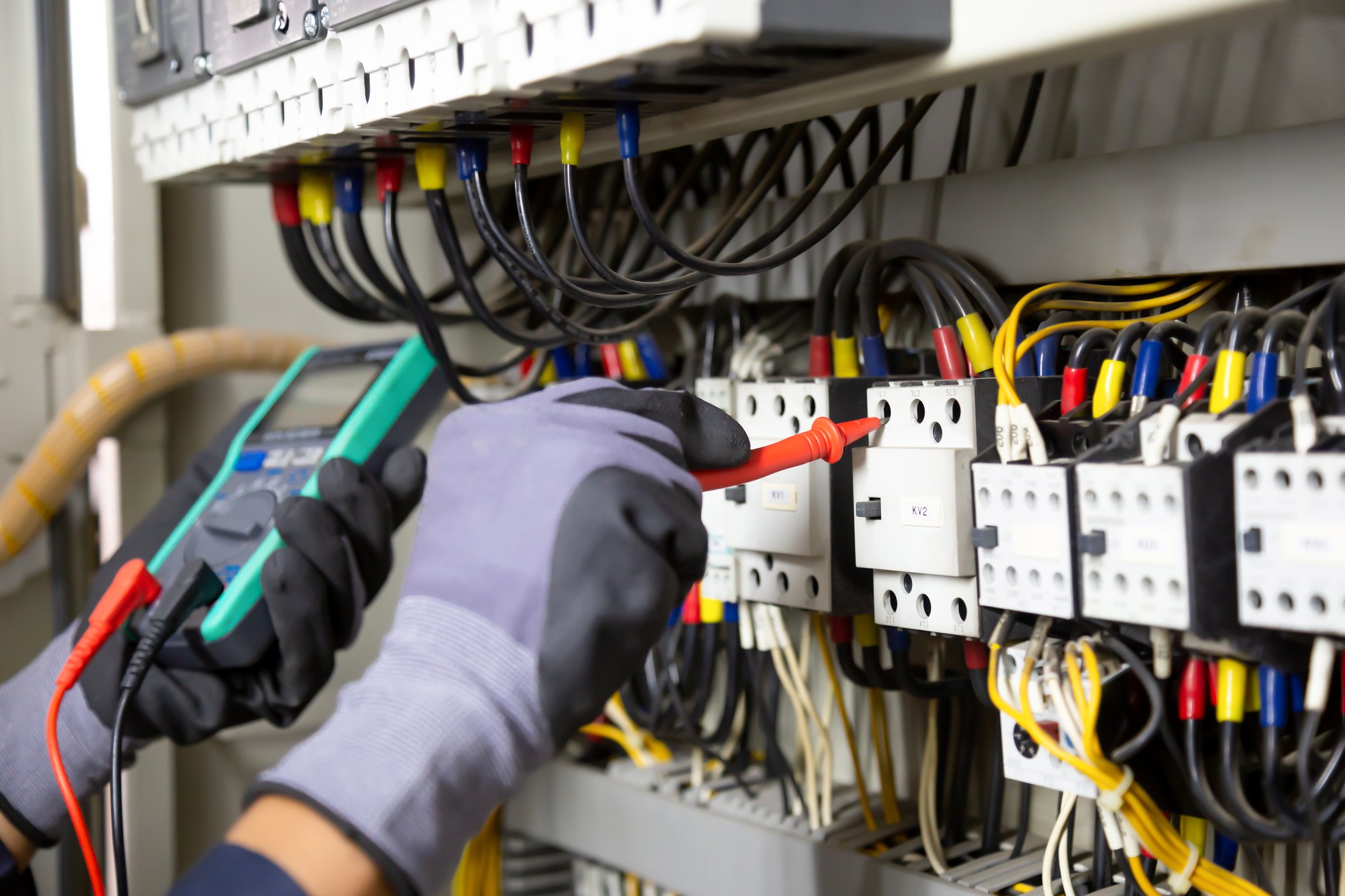 Electrician engineer tests electrical installations and wires on relay protection system