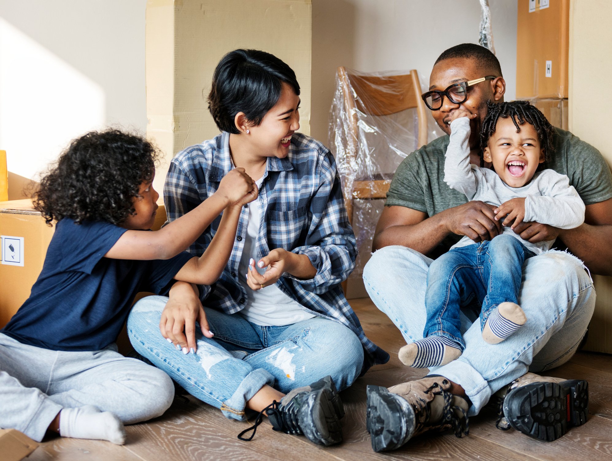 22_01_17 Two adults and two children in a room with packing boxes _GettyImages-922730214