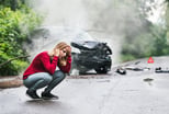 with smartphone by the damaged car after a car accident