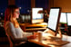 woman sitting in front of computer in office late at night -- working job stress businesswoman