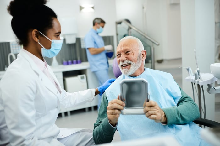 Person smiling after a visit to the dentist.