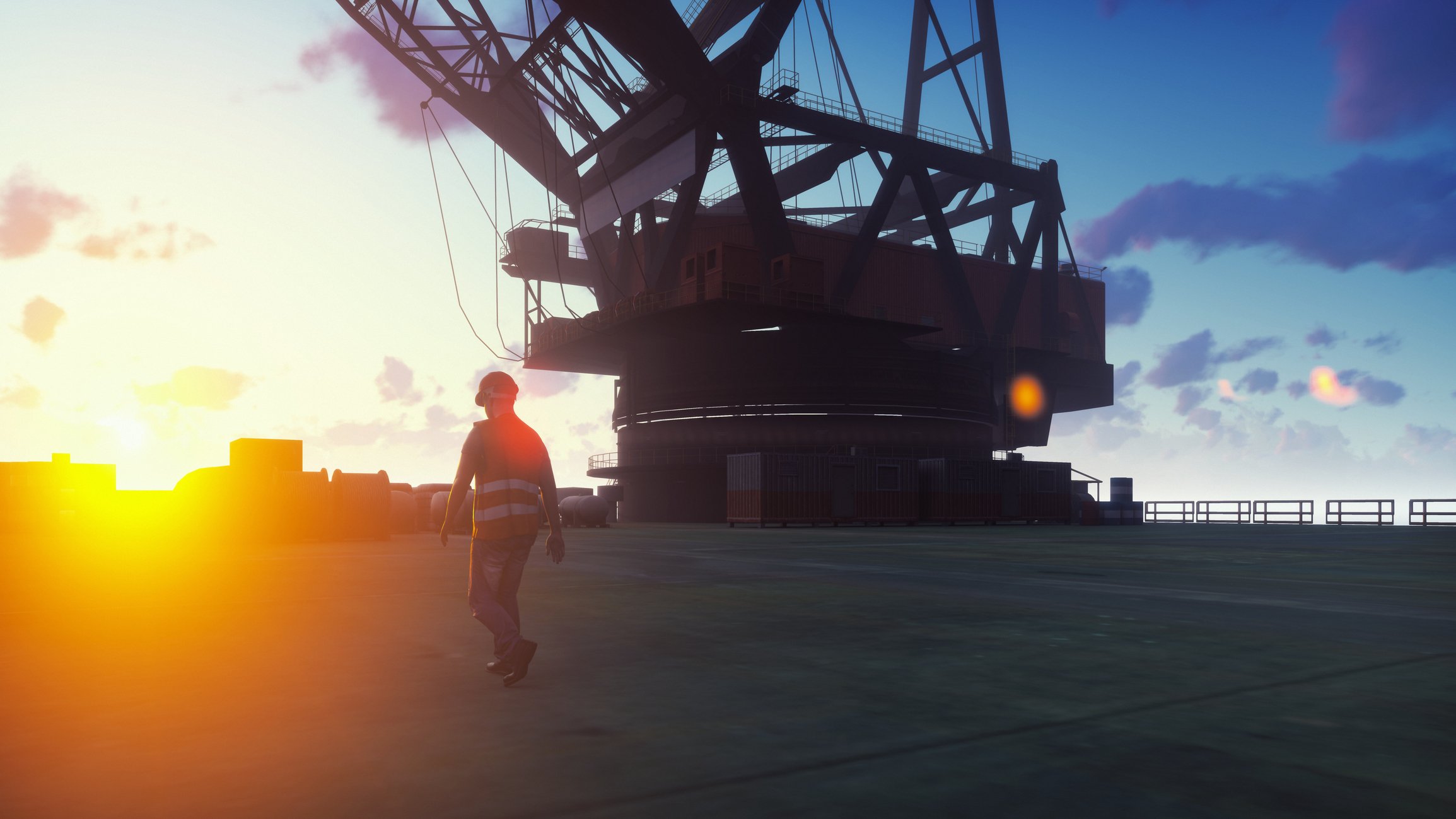 Worker walking across an oil platform at sea near either dawn or dusk