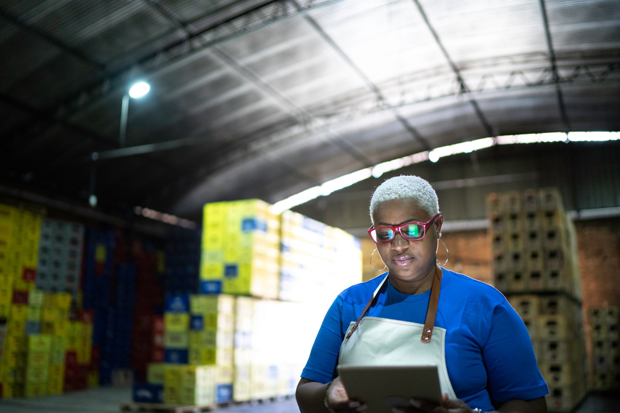 Industrial tech employee using digital tablet at warehouse Getty