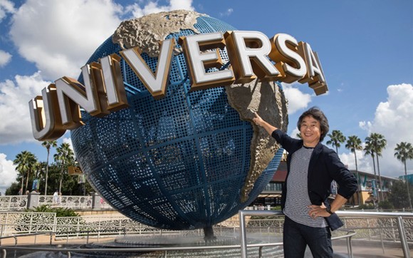 Man poses in front of Universal Studios signature globe.