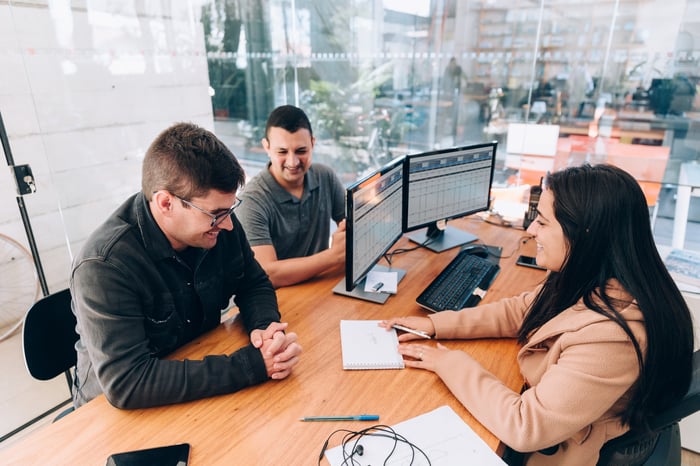 A financial advisor working with a couple in their office.