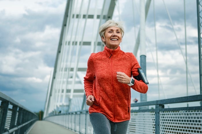 An older person doing cardio and working out outdoors.