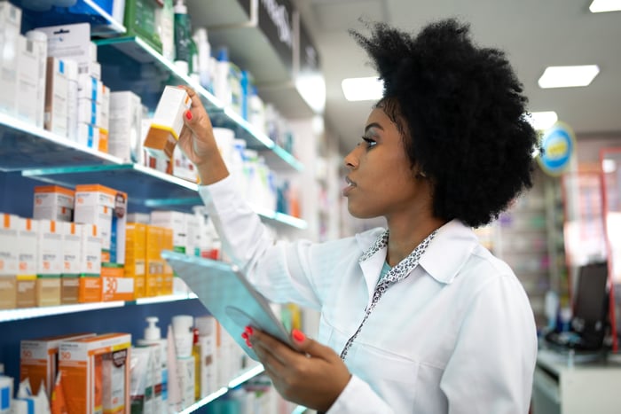 Pharmacist taking inventory with a digital tablet at the pharmacy.