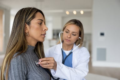 A doctor placing a stethoscope on a person's chest_GettyImages-1370591144