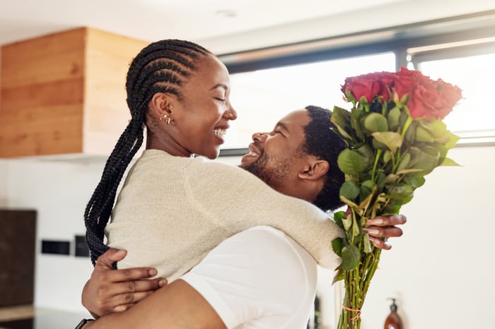 hugging couple, holding flowers.