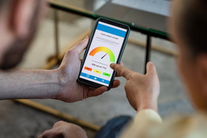 People looking at a credit score on a cell phone.