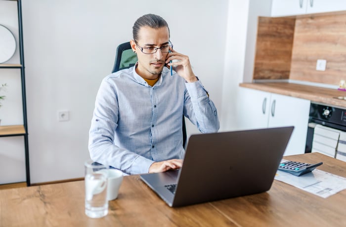 A person with a serious expression at a laptop.