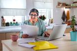 A person at desk, looking at documents and data.