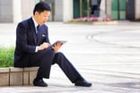 A business person sitting outside