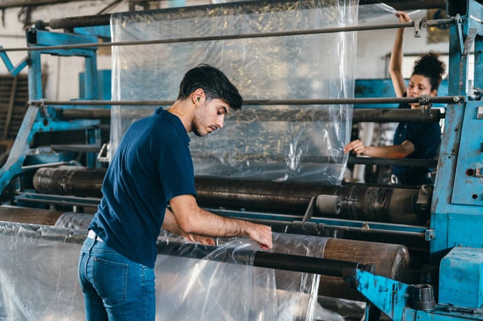Two people working in a plastics factory.
