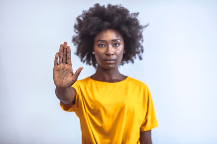 A person putting her hand up to say stop.