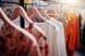 clothing hanging on a rack in a store fashion retail apparel clothes