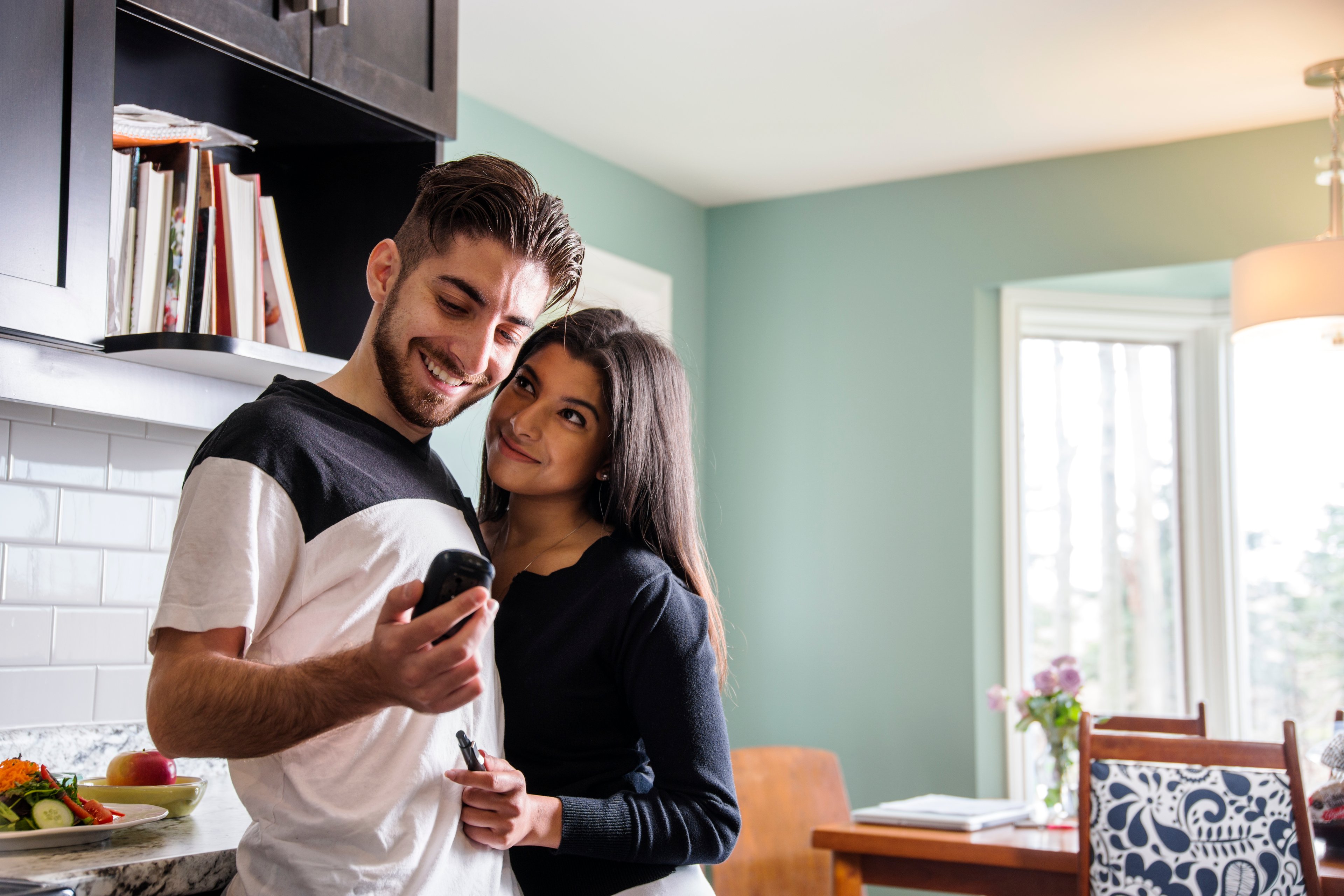 man with diabetes checking blood sugar levels with wife