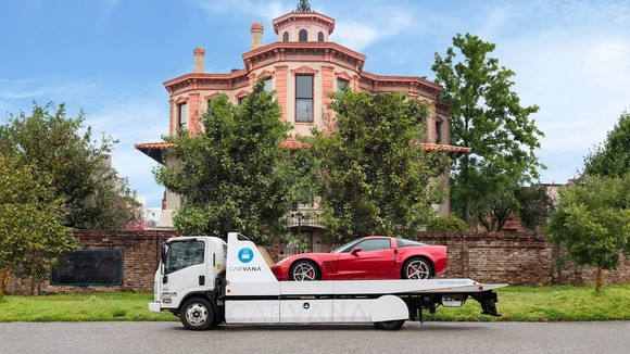 A Carvana vehicle is delivered to a home.