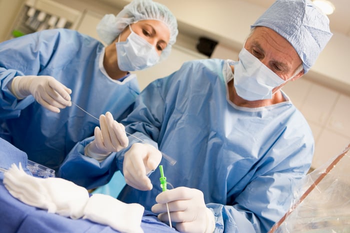 Two medical professionals performing surgery.