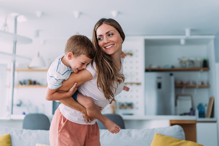 A person holding a child on their back.