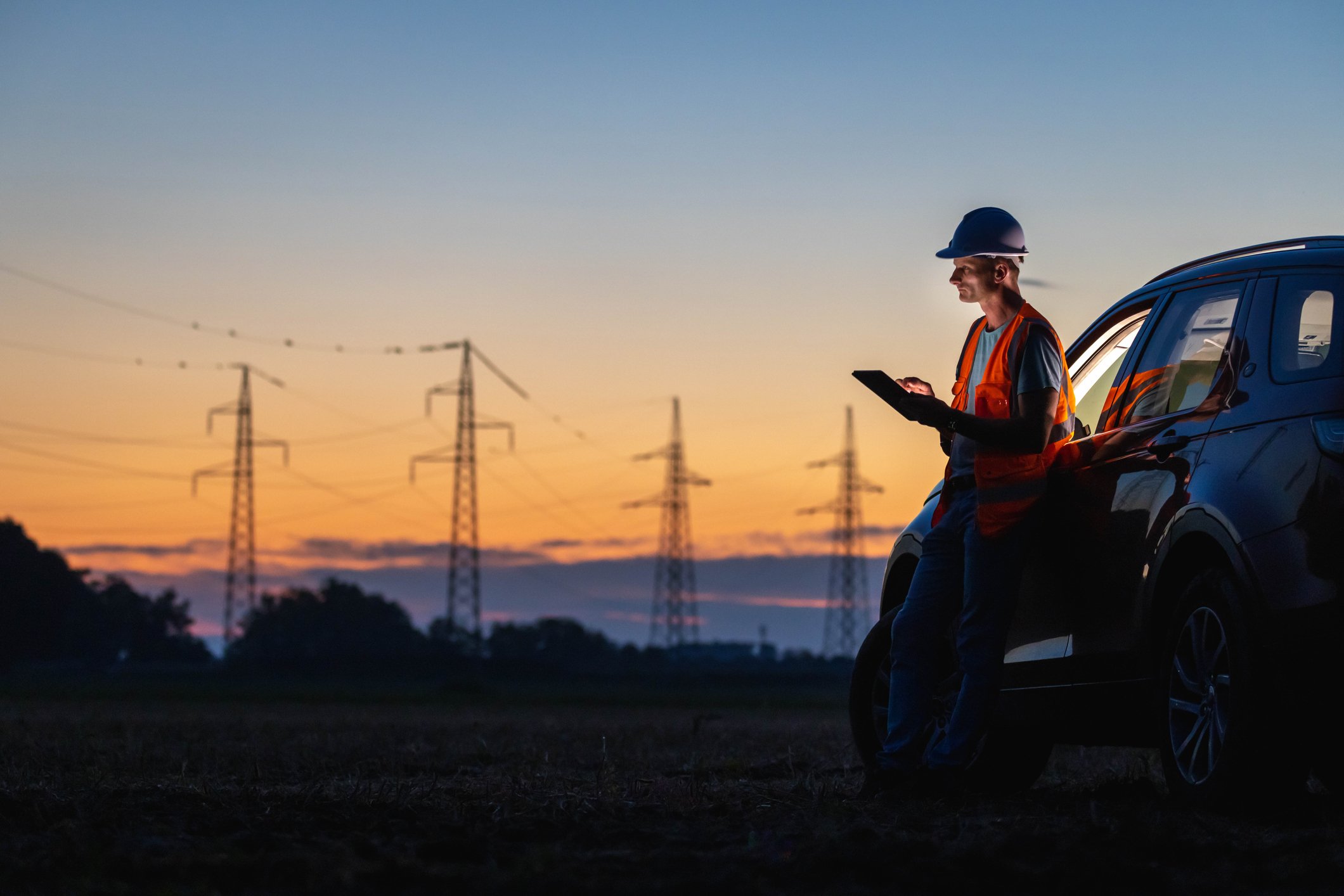 Engineer using digital tablet near car power lines