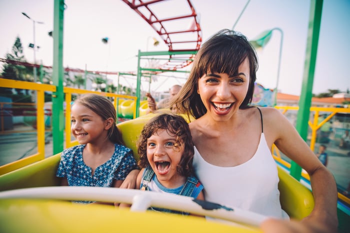 Three people on an amusement park roller coaster.