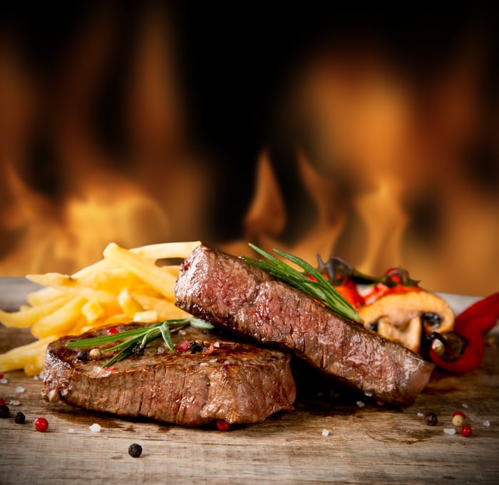 A steak being cooked over a fire.