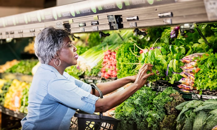 A person reaching for produce.