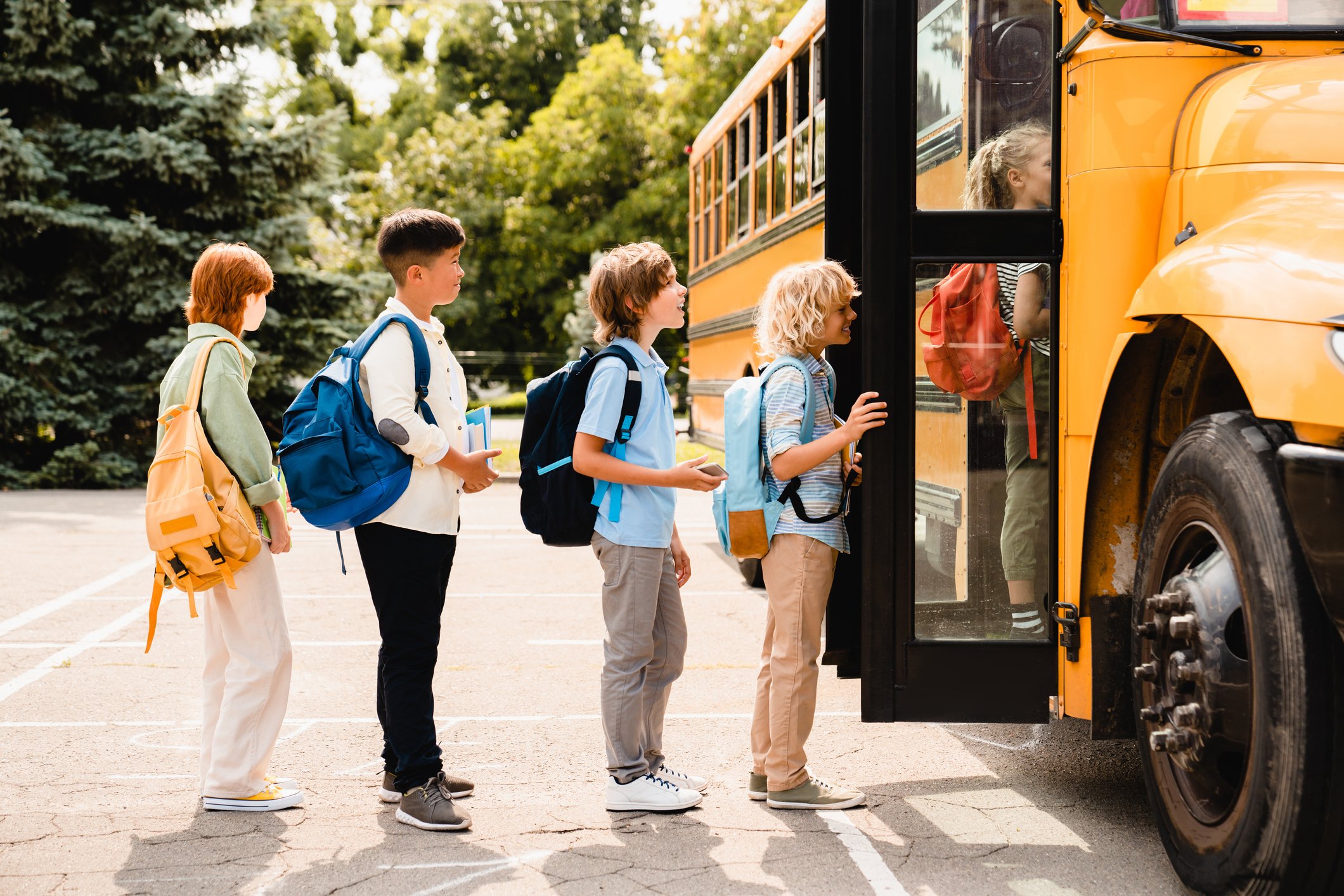 classmates students children waiting in line for school bus
