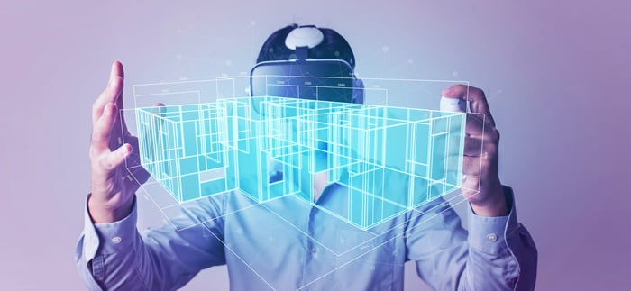 A person studies a VR model of a house.