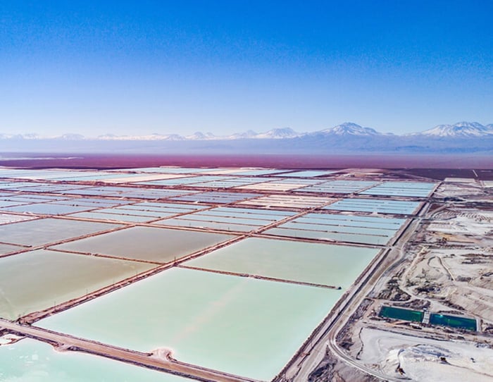 Large lithium brine evaporation pools in foreground, mountains in background. 