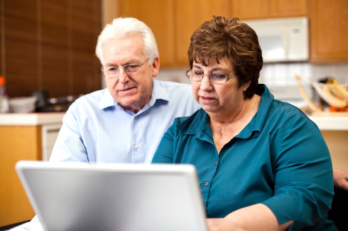 Two people with serious expressions at a laptop.