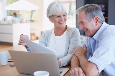Senior couple smiling laptop GettyImages-495809094