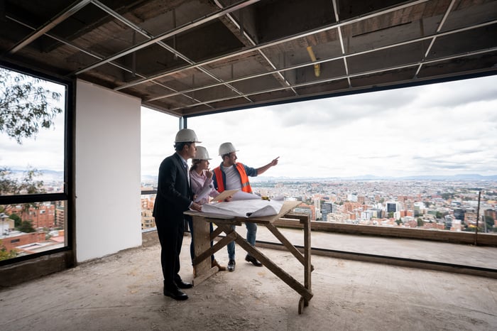 A contractor, architect, and engineer working as a team at a construction site.