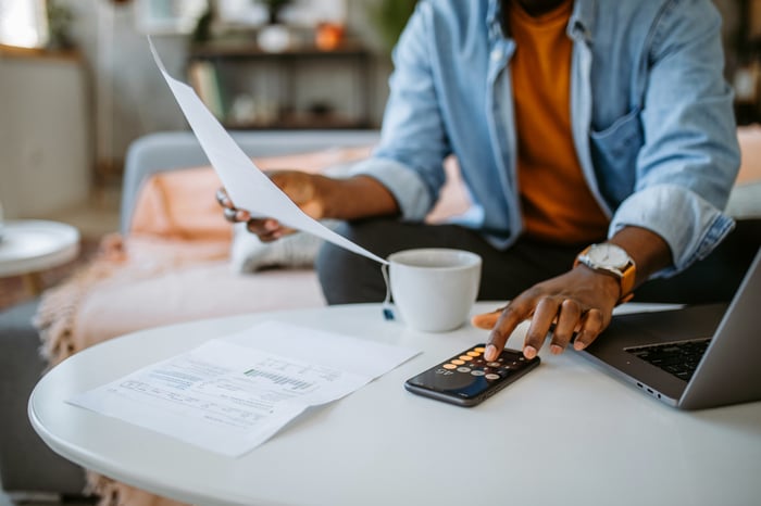 Person using calculator looking at financial paperwork.